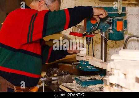 Falegname lavora in un laboratorio per la produzione di annata mobili Foto Stock