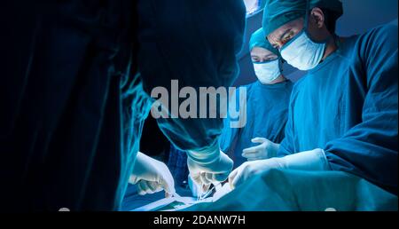 gruppo medico chirurgico concentrato un paziente nella sala operatoria dell'ospedale. concetto medico e sanitario. Foto Stock