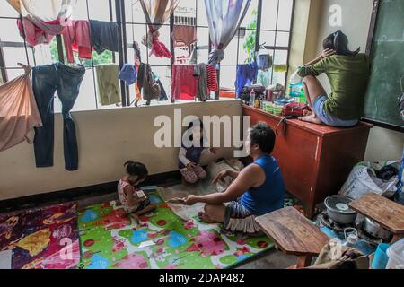 Rizal, Filippine. 14 novembre 2020. Una famiglia prende rifugio con i loro beni all'interno di un centro di evacuazione convertito da una scuola dopo l'alluvione portata da Typhoon Vamco nella provincia di Rizal, nelle Filippine, il 14 novembre 2020. Il tributo di morte del tifone Vamco che ha martoriato le Filippine questa settimana è salito a 53, la polizia nazionale filippina (PNP) ha detto sabato. Il tifone Vamco ha incassato gran parte di Luzon, che ospita circa la metà dei 110 milioni di abitanti del paese e il 70% dell'attività economica. Credit: Rouelle Umali/Xinhua/Alamy Live News Foto Stock