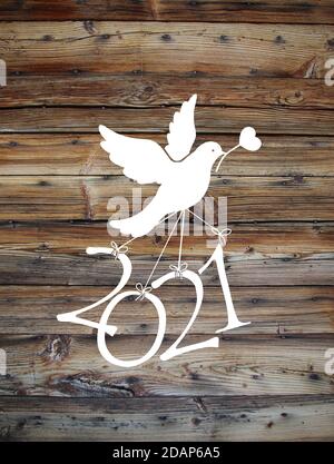 Una colomba bianca porta il numero '2021' su un legno sfondo Foto Stock