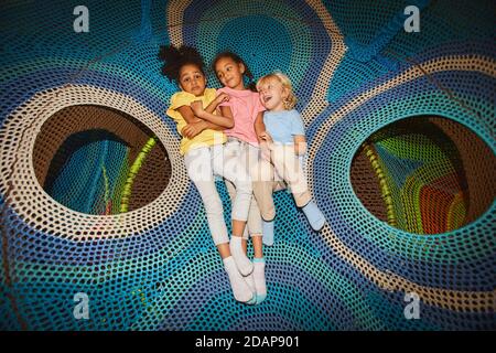 Vista ad alto angolo di un gruppo felice di bambini che si stendano grande amaca insieme e riposante Foto Stock