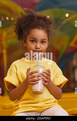 Ritratto della bambina africana che beve il cocktail di latte dal bere paglia Foto Stock