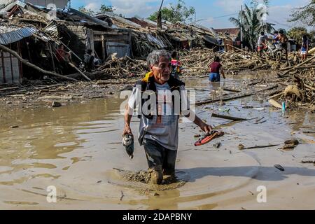 Rizal, Filippine. 14 novembre 2020. I residenti si guastano attraverso il fango profondo del ginocchio mentre trasportano i loro beni recuperati dalle case danneggiate dopo l'alluvione portata da Typhoon Vamco nella provincia di Rizal, nelle Filippine, 14 novembre 2020. Typhoon Vamco ha attraversato l'isola principale delle Filippine di Luzon da mercoledì a giovedì, innescando inondazioni e frane in molte regioni e lasciando almeno 53 morti. Credit: Rouelle Umali/Xinhua/Alamy Live News Foto Stock