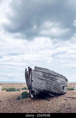 Una barca abbandonata rotta sul paesaggio stellato di Dungeness, Kent. Foto Stock