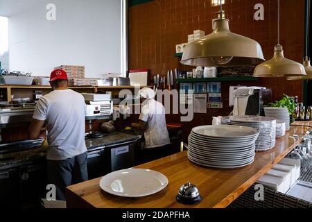 Un operaio di una pizzeria che indossa una maschera facciale attende gli ordini prima della chiusura alle 13.00.primo fine settimana di parziale reclusione in Portogallo entrato in vigore il 4 novembre, in cui 191 comuni in Portogallo in cui vi è un "elevato rischio di trasmissione da Covid-19", il dovere di rimanere a casa (nei giorni feriali dalle 11 alle 5 e nei fine settimana dalle 13). Alcuni ristoranti, caffè sono stati colpiti da questa misura, optando per la chiusura, altri rimangono aperti solo per il take away, il 14 novembre 2020, Matosinhos. Foto Stock