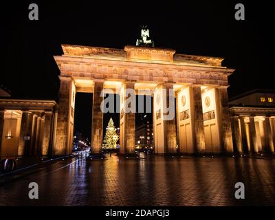 Ritorno della porta di Brandeburgo a Natale e Hanukkah, con albero di Natale e Hanukkah menorah sullo sfondo Foto Stock