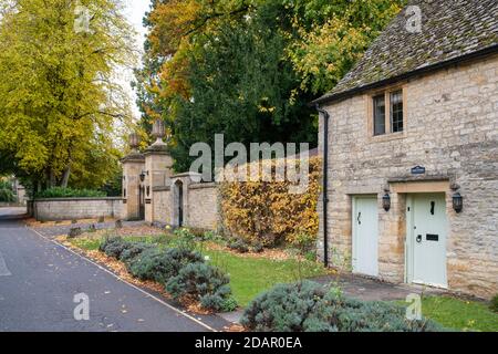 Cottage in pietra Cotswold e l'ingresso alla residenza Slaughtes in autunno. Macellazione inferiore. Cotswolds, Gloucestershire, Inghilterra Foto Stock