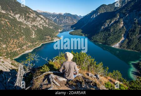 L'escursionista si riposa e guarda in lontananza, dietro Schojouechl, Plansee, Alpi Ammergau, Reutte, Tirolo Foto Stock