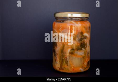 Vasetto di Kimchi, cibo tipico coreano fatto con cavolo coreano, cetriolo e spezie su sfondo bianco e nero. Foto Stock