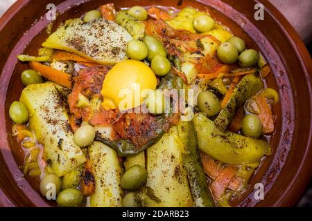 Tajine, cibo tipico marocchino in creta pentola, pollo con limone e olive, verdure e patate, Marocco Foto Stock