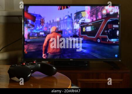 KHARKOV, UCRAINA - 12 NOVEMBRE 2020: Controller di videogiochi Gamesir g3s sul tavolo con Watch Dogs Legion game sul grande schermo Foto Stock