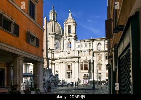 Un vicolo che conduce a Piazza Navona con l'Obelisco, la Fontana dei quattro fiumi e Sant'Agnese ad Agone in vista una mattina presto a Roma Italia Foto Stock
