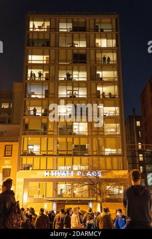 Washington, Stati Uniti. 14 novembre 2020. Gli spettatori nelle finestre dell'Hyatt Place Hotel guardano verso il basso alla folla di alcuni "MYLION MAGA marchers" e dimostranti anti anti anti di Trump dopo la loro marcia alla Corte Suprema di Washington, DC, sabato 14 novembre 2020. Foto di Ken Cedeno/UPI Credit: UPI/Alamy Live News Foto Stock