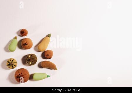 Le piccole e graziose zucche e i cavoli realizzati con verdure da impasto modellato in un angolo isolato su bianco. Foto Stock