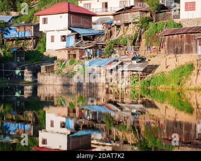 Akha villaggio nelle montagne del Laos del Nord, cielo drammatico del tramonto. Remoto villaggio tribale destinazione di viaggio per trekking tribale, Akha gruppo etnico e. Foto Stock