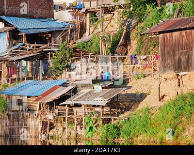 Akha villaggio nelle montagne del Laos del Nord, cielo drammatico del tramonto. Remoto villaggio tribale destinazione di viaggio per trekking tribale, Akha gruppo etnico e. Foto Stock