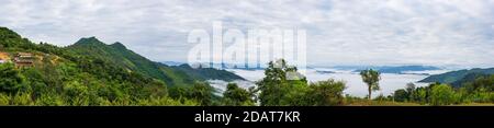 Akha villaggio nelle montagne del Laos del Nord, cielo drammatico del tramonto. Remoto villaggio tribale destinazione di viaggio per trekking tribale, Akha gruppo etnico e. Foto Stock