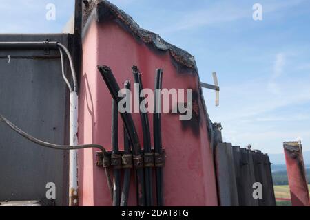 tagliare i cavi elettrici su una parete rosa di un rovinato edificio Foto Stock