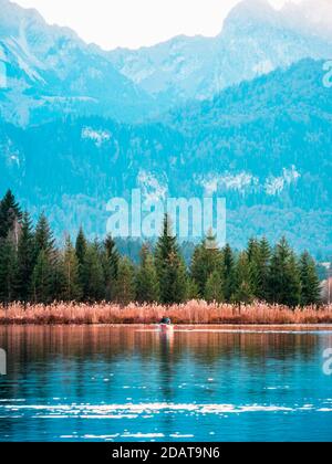 Lago con montagne e barche nel paesaggio Foto Stock