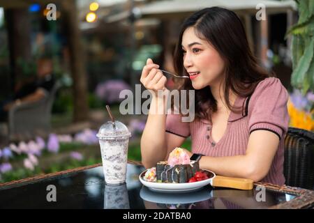 donna che mangia pane tostato, dolce dessert nel caffè Foto Stock