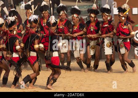 Tribesmen di Naga vestiti in abbigliamento tradizionale che esegue la danza tradizionale durante Hornbill festival a Nagaland India il 4 dicembre 2016 Foto Stock