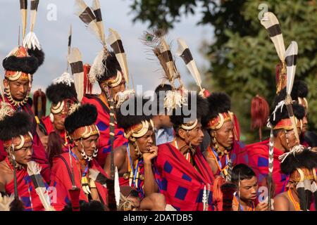 I tribisti di Naga indossano il loro abbigliamento tradizionale e si siedono insieme Kisama Village Arena a Nagaland India il 4 dicembre 2016 Foto Stock