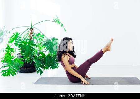 Donna orientale impegnata nella classe di yoga asana ginnastica fitness flessibilità Foto Stock