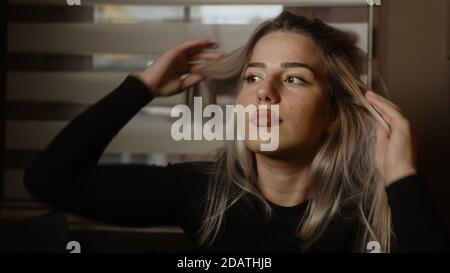 La giovane donna bionda annoiata si pone guardando la macchina fotografica, lo stile di vita e il concetto pandemico Foto Stock