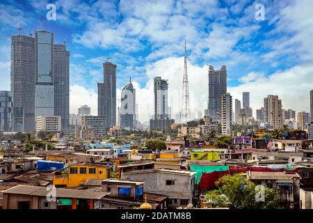 Vista delle baraccopoli sulle rive di mumbai, India sullo sfondo dei grattacieli in costruzione Foto Stock