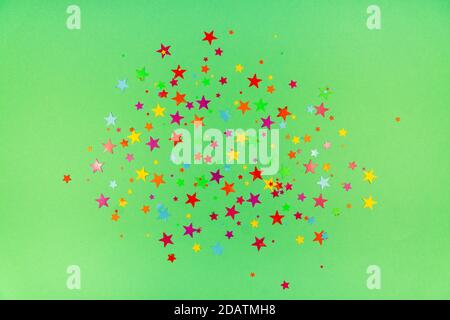 sfondo multicolore di stelle colorate confetti su sfondo verde Foto Stock