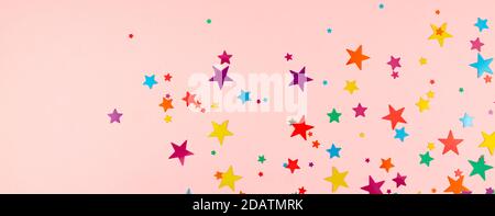 sfondo multicolore di stelle colorate confetti su sfondo rosa. Foto Stock