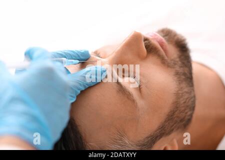 Closeup di uomo bearded che ottiene l'iniezione di bellezza alla clinica Foto Stock