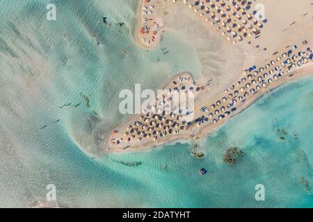 Vista aerea dall'alto degli ombrelloni presso la spiaggia di Elafonisi, una delle destinazioni turistiche più popolari nel sud-ovest di Creta, Grecia Foto Stock