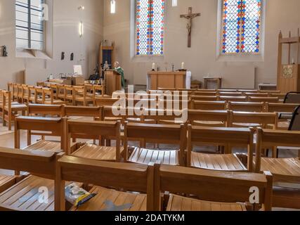 Un sacerdote predica a una chiesa vuota durante il blocco, la congregazione sta seguendo su Zoom e Facebook Foto Stock