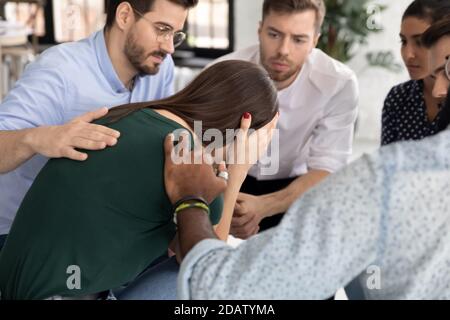 Piangendo millennial femmina che ha problemi a prendere parte alla terapia di gruppo Foto Stock