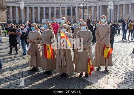 VATICANO ROMA ITALIA 15 NOVEMBRE 2020. Le monache cattoliche spagnole che indossano maschere protettive si uniscono ai fedeli mentre guardano Papa Francesco che consegna la benedizione della preghiera dell'Angelus dalla finestra del suo appartamento in Piazza San Pietro, nella giornata mondiale dei poveri. Le folle sono più piccole del solito a causa della pandemia del coronavirus. Credit: amer Ghazzal/Alamy Live News Foto Stock