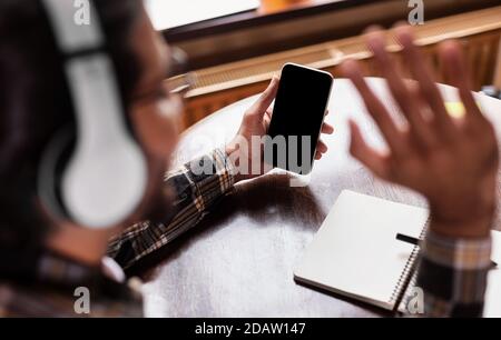 Indian Student Guy si sta muovendo verso il telefono facendo videochiamare all'interno Foto Stock