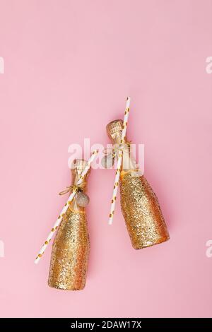 Mini bottiglie di champagne decorate con glitter dorato e carta cannucce Foto Stock