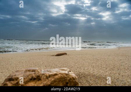 Sole che si riversa sul mare attraverso le nuvole vista da spiaggia di tempio somnath Gujarat India Foto Stock