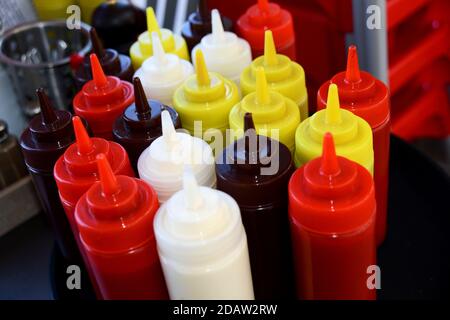 Bottiglie di salse colorate in una caffetteria a Brighton, East Sussex, Regno Unito. Foto Stock