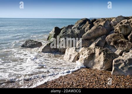 Onde che lambellano le rocce sulla spiaggia di Highcliffe Dorset Foto Stock