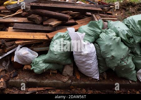 sacchi di spazzatura con i detriti di costruzione sulla strada del città Foto Stock