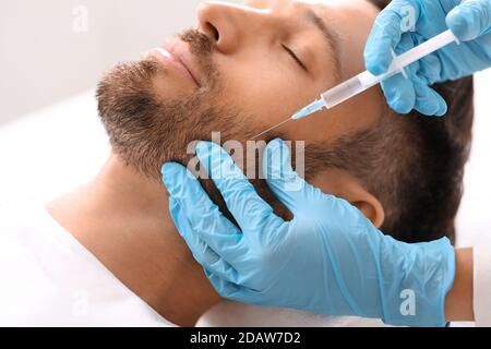 Closeup di uomo bearded che ottiene l'iniezione di bellezza alla clinica Foto Stock