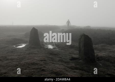 Le condizioni di Misty fanno per le condizioni atmosferiche di camminata per i corridori ed i camminatori del cane al cerchio di pietra di 12 Apostoli su Ilkley Moor, West Yorkshire, U Foto Stock