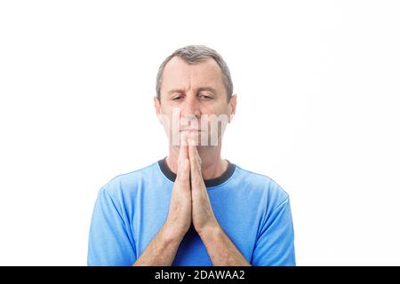 Uomo depresso di mezza età che prega su sfondo bianco. Uomo di mezza età che prega per aiuto con uno sguardo disperato su sfondo bianco. Foto Stock