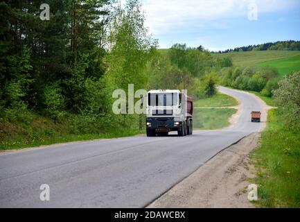 Cassone ribaltabile il dumper ha trasportato la sabbia dalla cava durante la guida in autostrada. Moderno dumper per per impieghi pesanti con scarico merci da solo tramite idraul Foto Stock