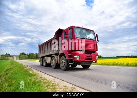 Cassone ribaltabile il dumper ha trasportato la sabbia dalla cava durante la guida in autostrada. Moderno dumper per per impieghi pesanti con scarico merci da solo tramite idraul Foto Stock