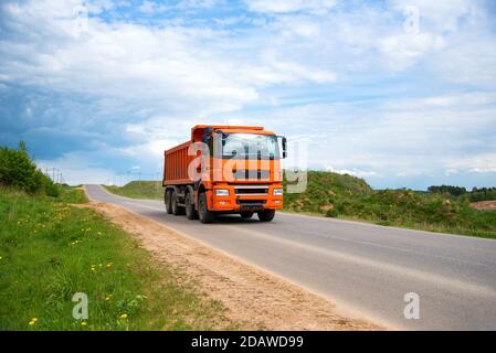 Cassone ribaltabile il dumper ha trasportato la sabbia dalla cava durante la guida in autostrada. Moderno dumper per per impieghi pesanti con scarico merci da solo tramite idraul Foto Stock