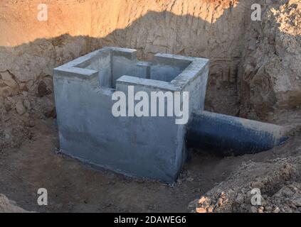 Costruzione di box per acque piovane, camera di distribuzione per impianti fognari sanitari e stazione di pompaggio. Fognature tombino e tubi linea in costruzione al Th Foto Stock