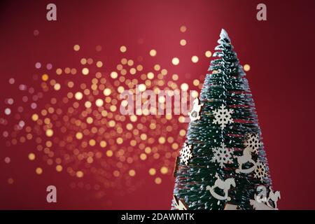 Albero di Natale su sfondo rosso. Natale senza sprechi Foto Stock